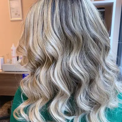 Meches bionde con degradè freddo su capelli lunghi mossi
