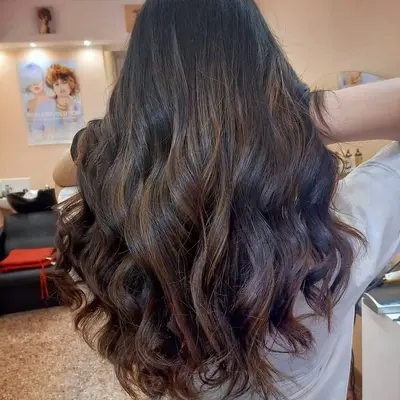 Capelli castano scuro con boccoli morbidi e punte più chiare