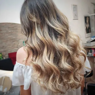 Balayage biondo luminoso con onde morbide su capelli lunghi